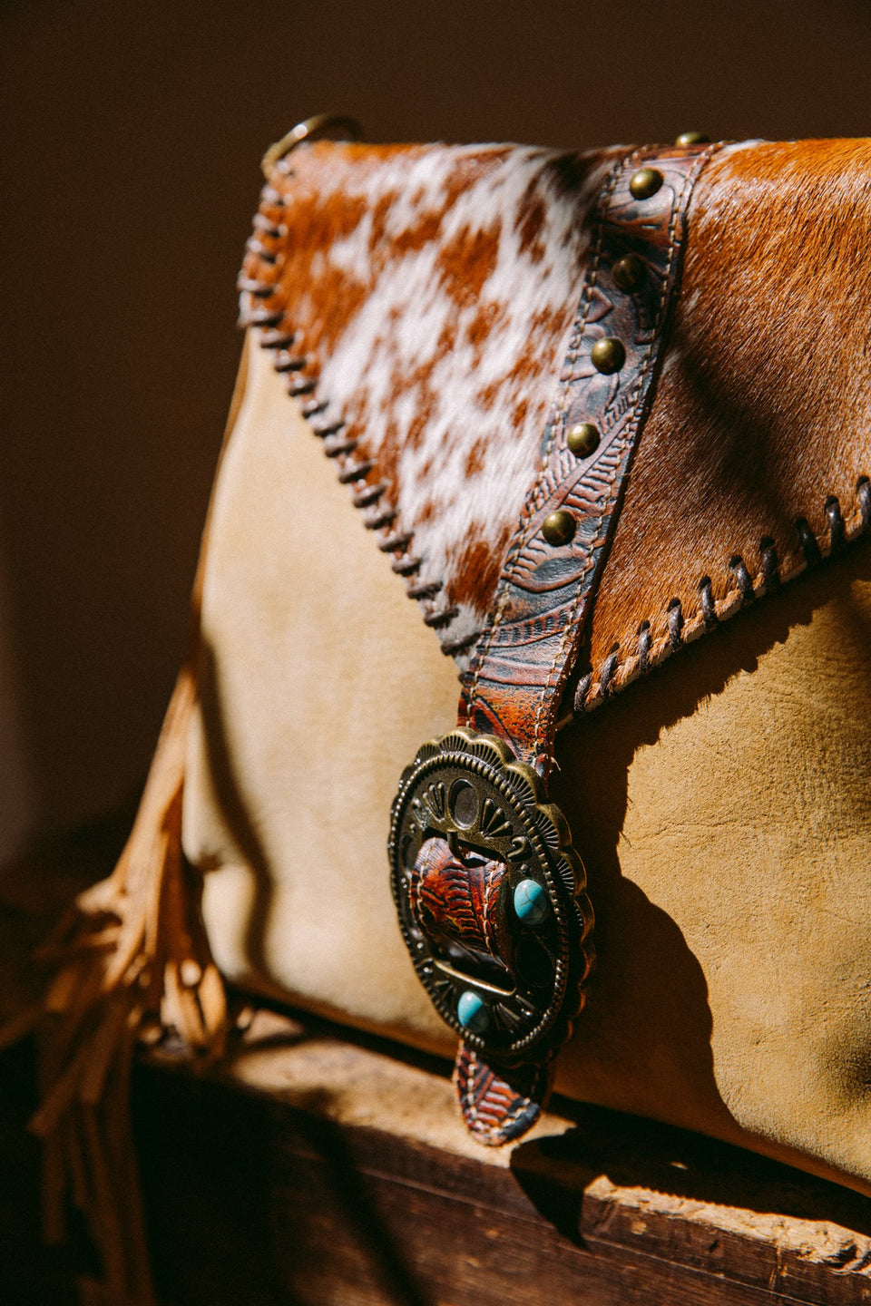 Leather cow hide purse with fringe and buckle